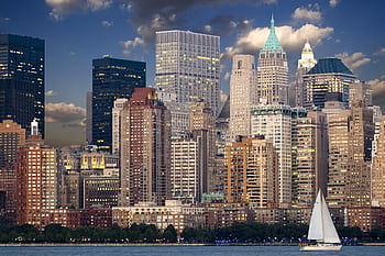 Panoramic view of New York City skyline with sailboat and river during twilight. HD wallpaper