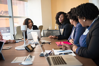 Diverse team of professionals engaging in a collaborative office meeting around a desk. HD wallpaper