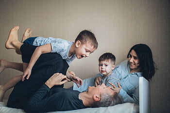 Joyful family bonding time indoors with parents and children having fun together. HD wallpaper