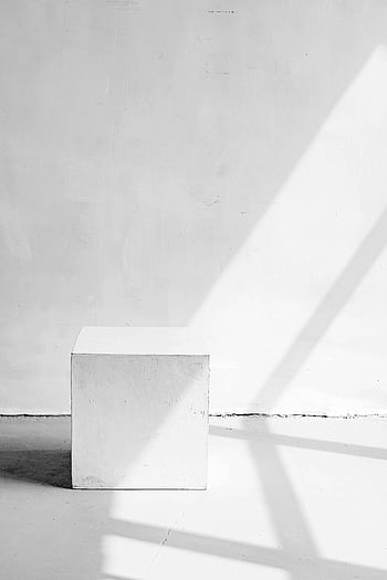 A stylish minimalist white cube in a sunlit room with dramatic shadows. HD phone wallpaper