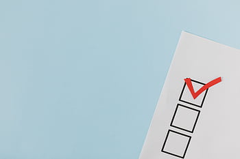 A checklist with a red checkmark symbolizing a completed task on a pastel blue background. HD wallpaper