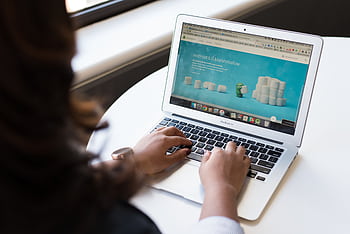 Businesswoman working on laptop with Android 6.0 Marshmallow webpage open. HD wallpaper