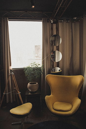 Warm and stylish room featuring yellow chair, plants, and mirrors. HD phone wallpaper