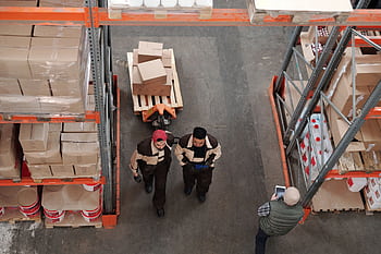 High angle view of warehouse workers organizing and preparing shipments with boxes and pallets. HD wallpaper