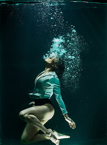 Dramatic of a woman diving underwater in stylish attire. HD phone wallpaper