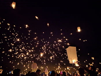A breathtaking view of floating lanterns illuminating the night sky during a vibrant festival. HD wallpaper