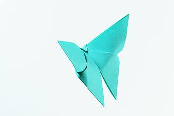 A vibrant blue origami butterfly crafted from paper on a white background. HD wallpaper