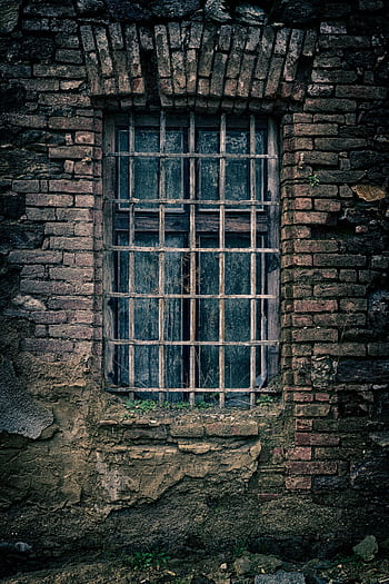 A moody close-up of an old brick wall featuring a barred window, capturing a sense of nostalgia. HD phone wallpaper