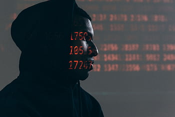 Side profile of a man in a hoodie, surrounded by red code, depicting cybersecurity theme. HD wallpaper