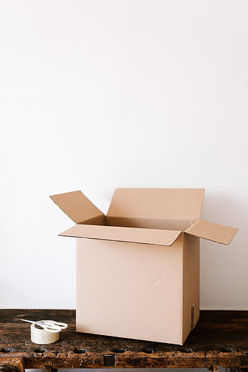 An open cardboard box on a weathered wooden table with tape and scissors beside it, ready for packing. HD phone wallpaper