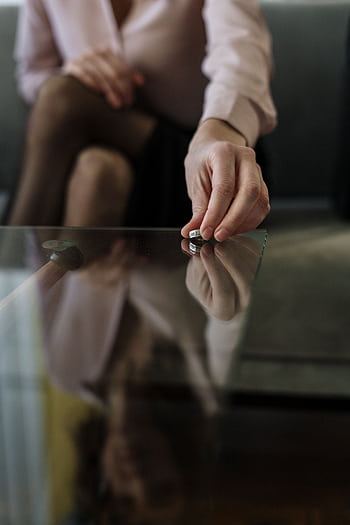A person placing a wedding ring on a glass table, symbolizing separation or divorce. HD phone wallpaper