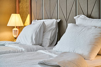 Inviting hotel room with comfortable bedding and ambient lighting, perfect for relaxation and luxury stay. HD wallpaper