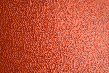 Detailed macro of orange leather texture, perfect for backgrounds or materials. HD wallpaper