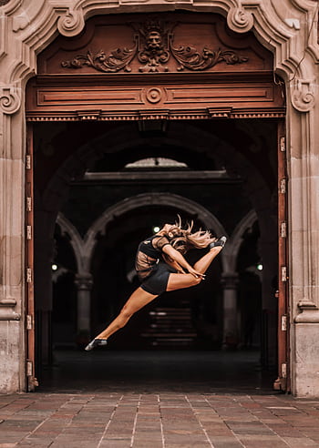 Ballet dancer performing a dramatic jump in a historic arch, Aguascalientes. HD phone wallpaper