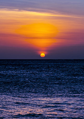 Breathtaking sunset view over the ocean from Aruba, casting vibrant colors across the sky and sea. HD phone wallpaper