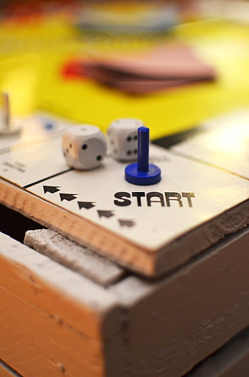 Close-up of a board game start position featuring dice and a blue game piece, perfect for leisure themes. HD phone wallpaper