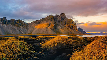 Black sand dunes, jagged peaks, and a crazy sunset at Stokksnes, Iceland, mountain, sea, Vestrahorn, plants, landscape, clouds, sky, rocks HD wallpaper
