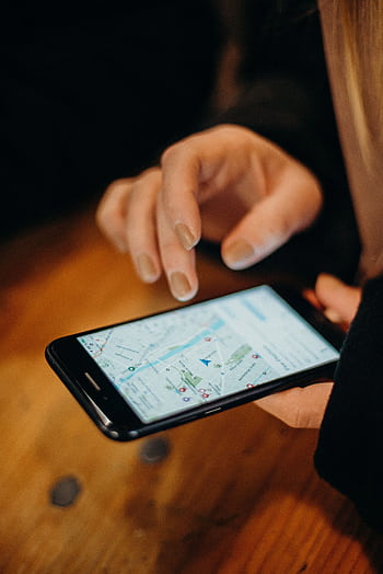 Close-up of a hand using a smart displaying a map for navigation. HD phone wallpaper