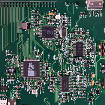 Detailed of a green circuit board featuring various components and microprocessors. HD phone wallpaper