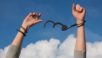 Symbolic of dom with open handcuffs against a bright blue sky. HD wallpaper