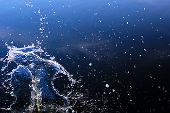 Captivating of a water splash against a dark backdrop, showcasing dynamic motion and texture. HD wallpaper