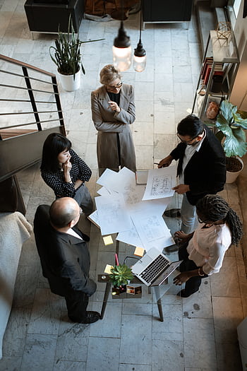 A team of professionals engage in a business meeting in a sleek, modern office setting. HD phone wallpaper