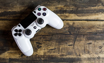 White game controller resting on a rustic wooden surface, top view. HD wallpaper