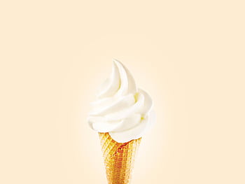 Close-up of a creamy soft serve ice cream cone on a bright background. HD wallpaper