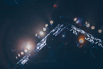 Bright stage lights illuminate a concert venue, creating a vivid and celebratory atmosphere. HD wallpaper