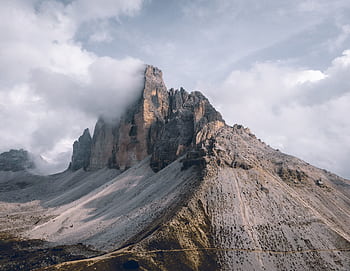 Majestic mountain peaks shrouded in clouds in a tranquil natural setting, perfect for nature enthusiasts. HD wallpaper