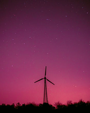 Wind turbine silhouette with a vibrant purple sky and stars, symbolizing renewable energy. HD phone wallpaper
