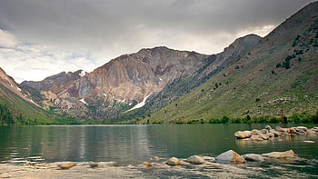 Surrounded Lake, grass, rocks, stones, mountain, lake, daylight, day, shine, clouds, nature, sky, water HD wallpaper