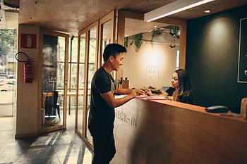 A customer checks in at a hotel reception desk in Belo Horizonte, Brazil. HD wallpaper