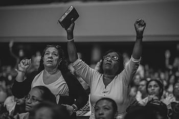 A heartfelt moment of worship in a crowded indoor religious gathering. HD wallpaper
