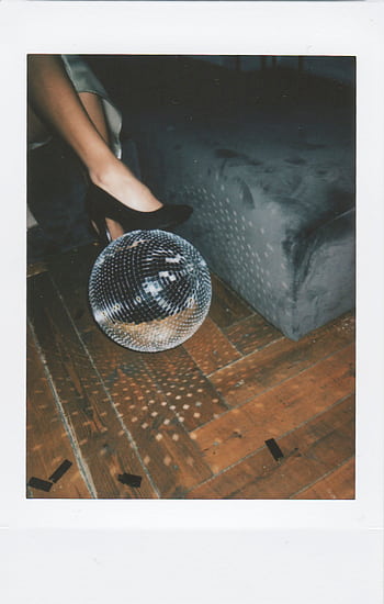 A stylish party scene featuring black heels and a reflective disco ball on a parquet floor. HD phone wallpaper