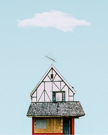 A quaint cottage roof and facade against a clear sky with a single cloud. HD phone wallpaper