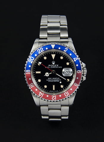 High-end stainless steel watch with dual tone bezel and date display on a dark background. HD phone wallpaper