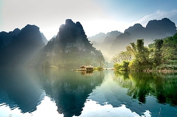 Stunning sunrise over a peaceful lake surrounded by lush mountains in Thượng Lâm, Vietnam. HD wallpaper