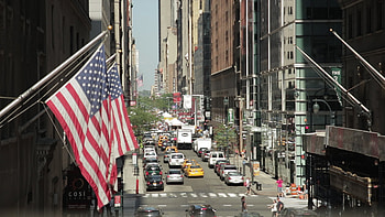 New York City street with US flag in foreground and traffic in background HD wallpaper