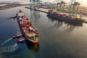 Aerial shot of cargo ships and cranes at North Jakarta port, showcasing global shipping and logistics. HD wallpaper