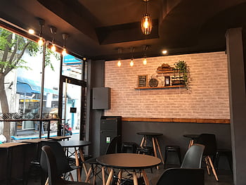 A stylish cafe interior featuring modern furniture and ambient lighting for a cozy atmosphere. HD wallpaper