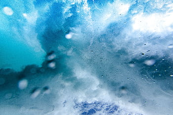 Captivating underwater view of an ocean wave bursting with vibrant blue textures and motion. HD wallpaper