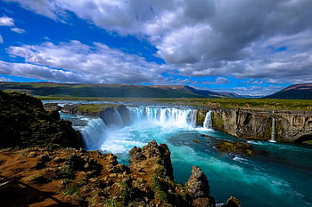 Stunning view of a vibrant waterfall in scenic nature, perfect for tranquil outdoor settings. HD wallpaper