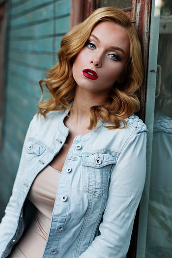 Portrait of a stylish woman with striking makeup and a denim jacket, exuding confidence. HD phone wallpaper