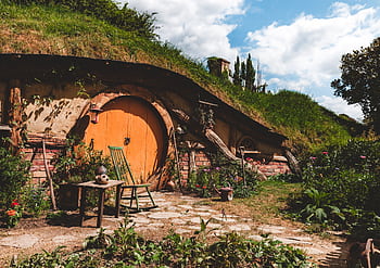 Explore a cozy hobbit house nestled in New Zealand's lush countryside, perfect for a rustic getaway. HD wallpaper