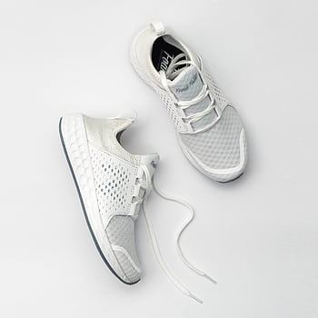 Pair of modern white sneakers with laces on a neutral backdrop. HD phone wallpaper
