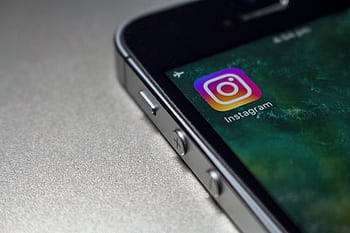 Close-up of a smart screen displaying the Instagram app icon, emphasizing modern technology. HD wallpaper