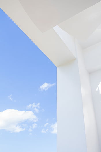 Sleek white structure with blue sky and clouds, showing minimalist architectural design elements. HD phone wallpaper