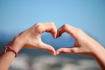 Close-up of hands forming a heart shape with clear blue sky background. HD wallpaper