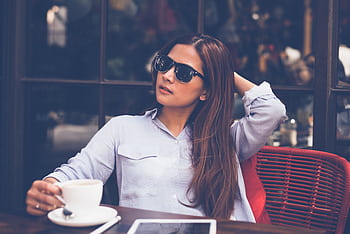 Woman enjoying a relaxed coffee break indoors with a tablet. Perfect for lifestyle and business themes. HD wallpaper